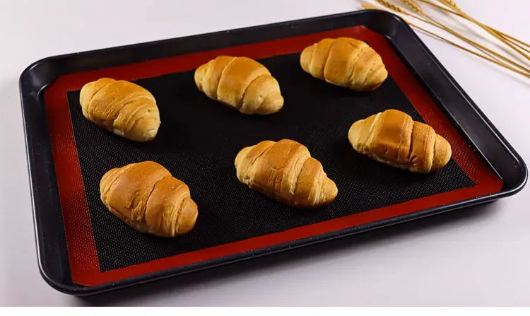 Bread rolls on a commercial tray with a silicone mesh liner